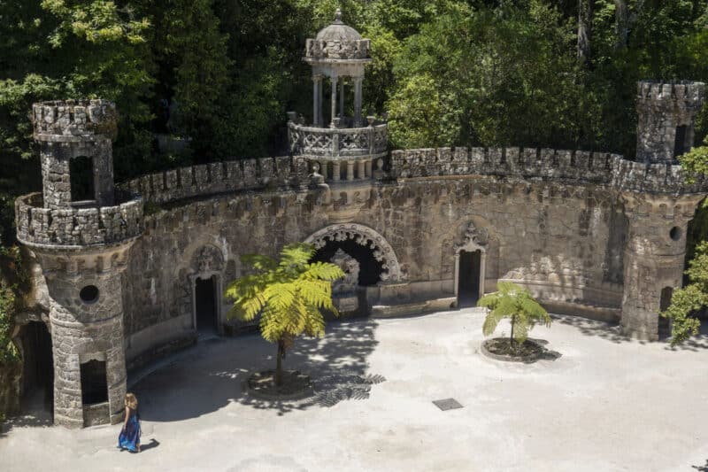 Quinta da Regaleira stone courtyard with Guardians of Portal towers and a central fountain 