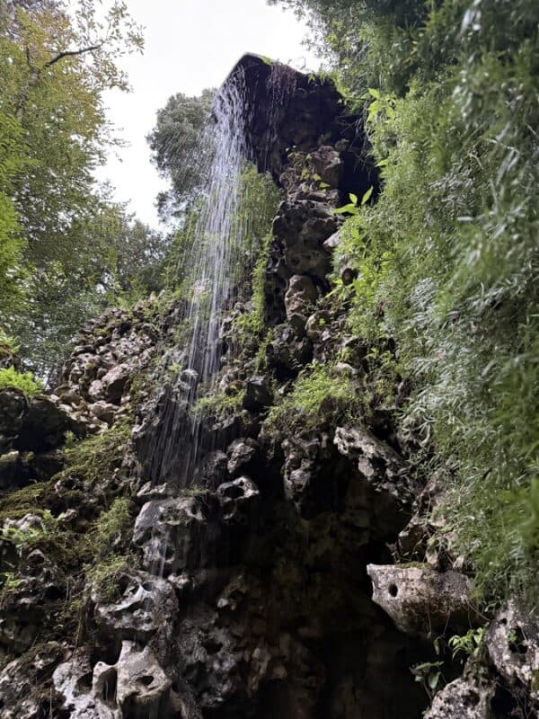Quinta da Regaleira waterfall among mossy rocks and lush greenery