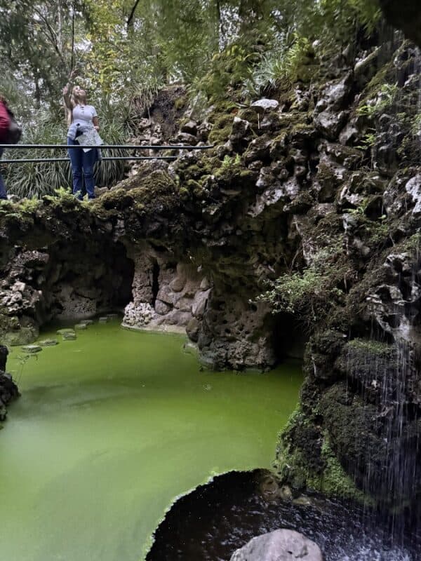 Quinta da Regaleira garden with a green pool, mossy rocks and waterfal