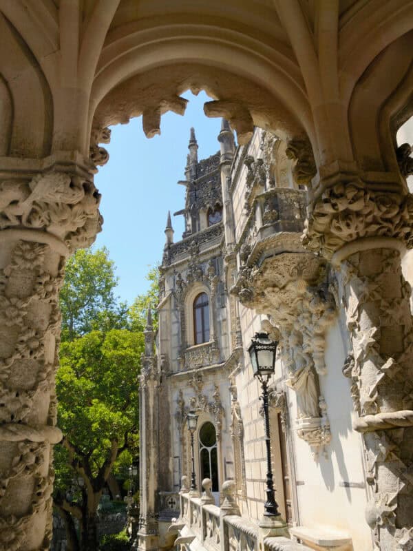 Quinta da Regaleira palace seen through an ornate stone archway