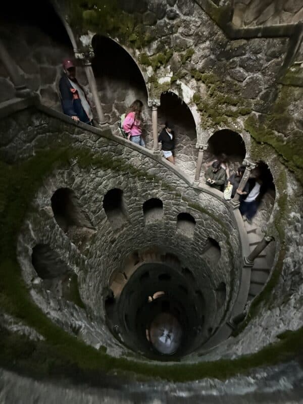 Quinta da Regaleira initiation well with visitors on the spiral staircase