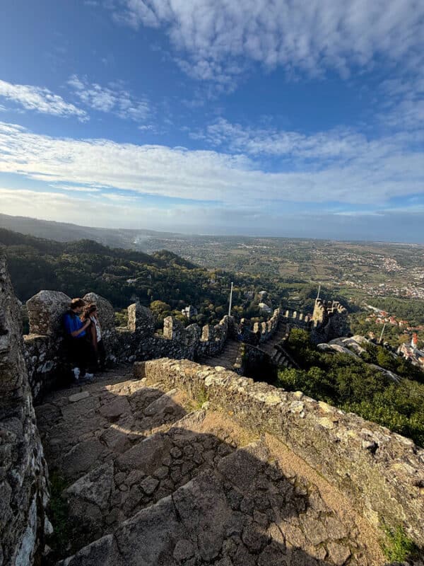 Moorish Castle hike in Sintra with tall stone steps, castle walls, low height parapet and wide views over the landscape