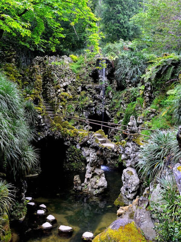 Quinta da Regaleira garden with mossy rocks, a waterfall and stepping stones
