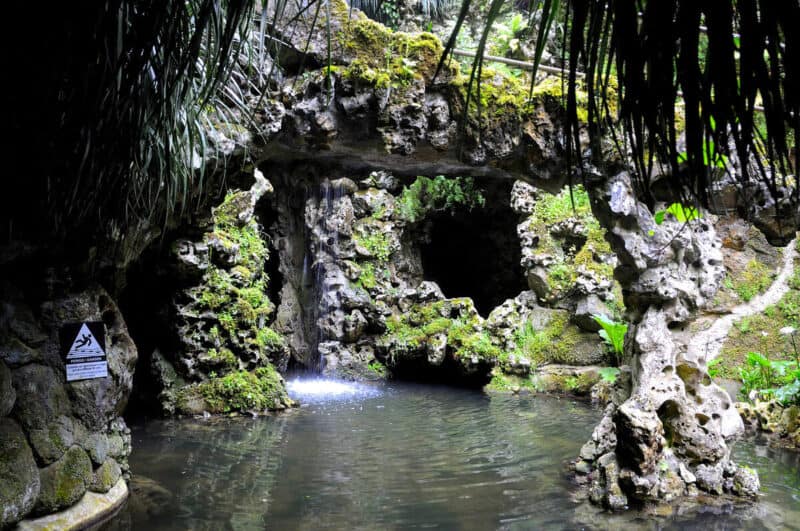 Quinta da Regaleira grotto with mossy rocks, a small waterfall and pool