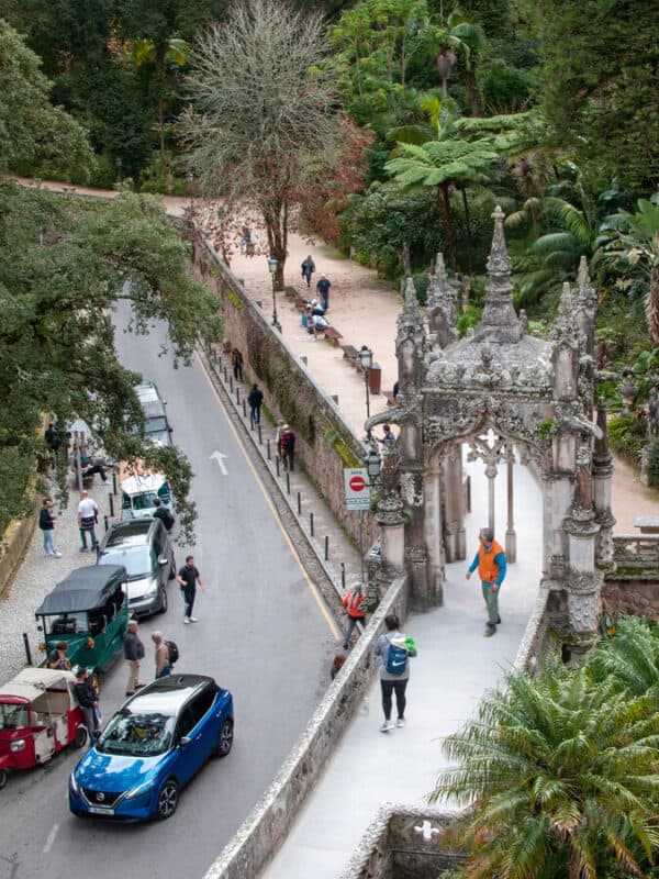 Quinta da Regaleira garden entrance with visitors, cars and palace grounds