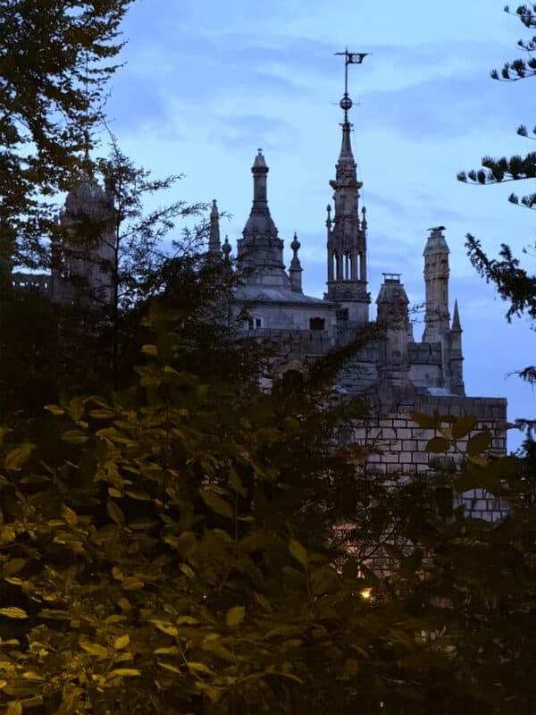 Quinta da Regaleira palace seen through trees at dusk