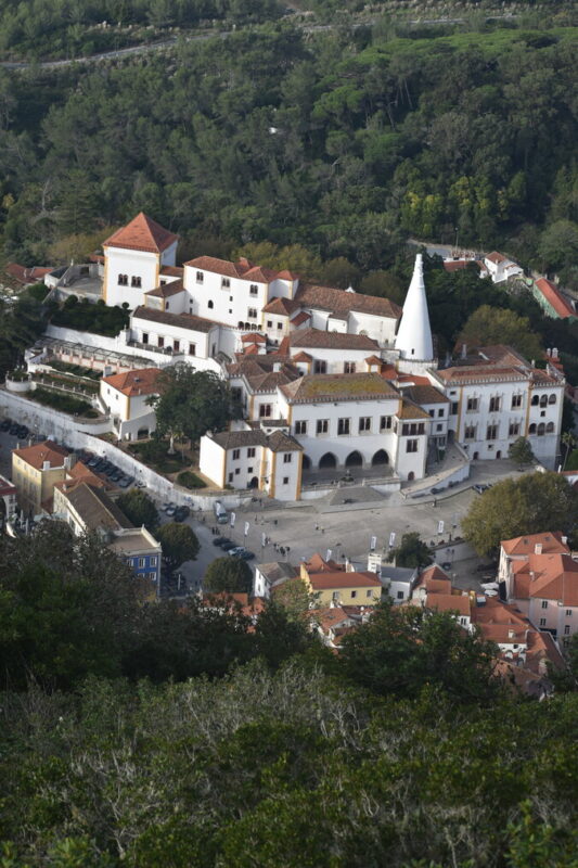 national palace of sintra seen from moorish castle with it's tall white chimneys 
