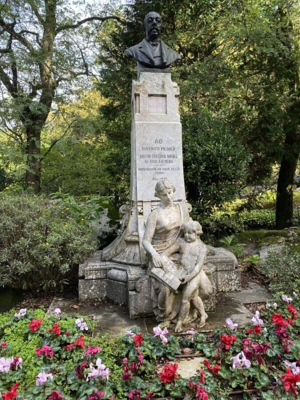 historic statues surrounded by rose plants by the side of Volta Do Duche in SIntra