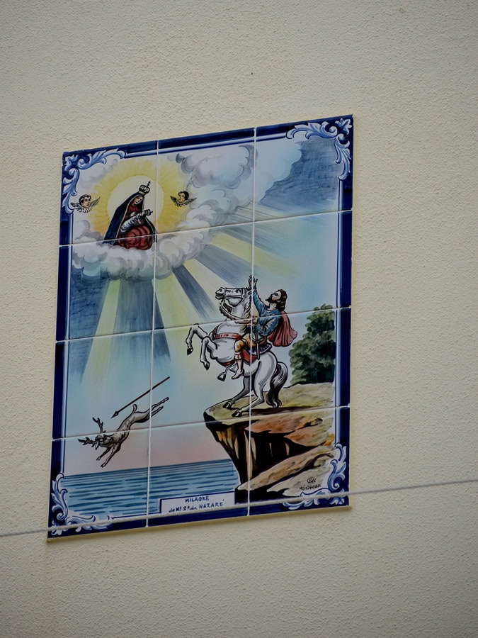 azulejo on house wall showing Dom Fuas Roupinho chasing a deer on horseback and virgin Mary saving her in Nazare
