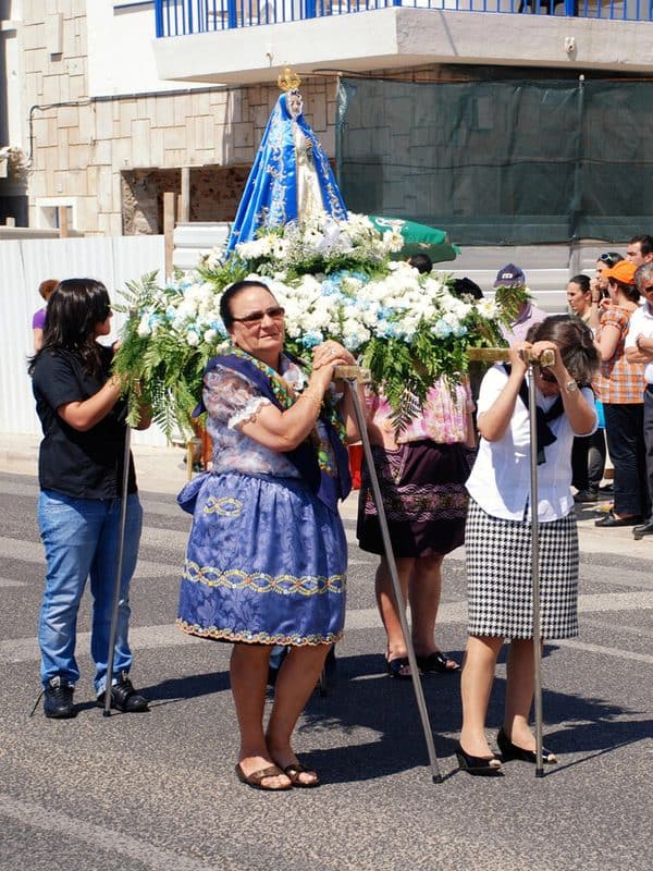 religious procession with women carrying a flower-covered virgin Mary statue through the streets
Romaria de Nossa Senhora da Nazare,